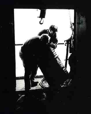 Paul Elvey & Tony Pine man handle oil drum